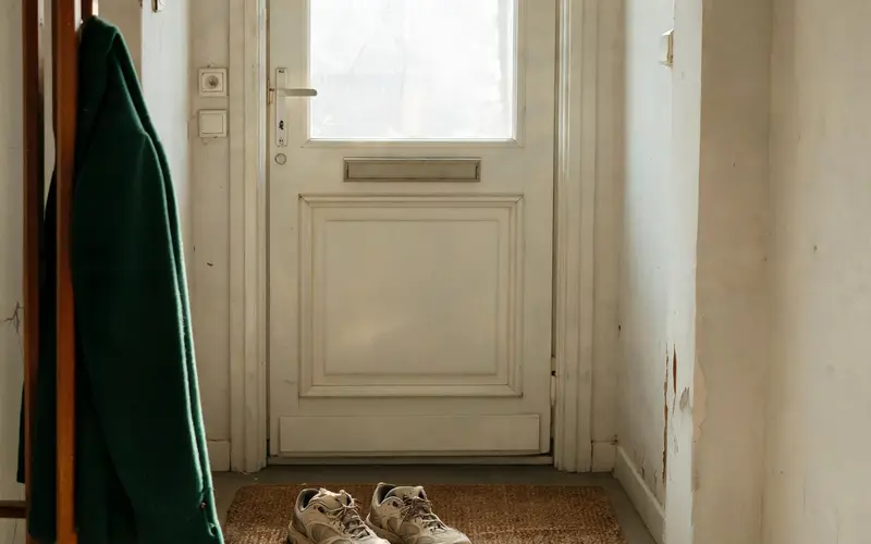 Wandelschoenen op een deurmat in een gang